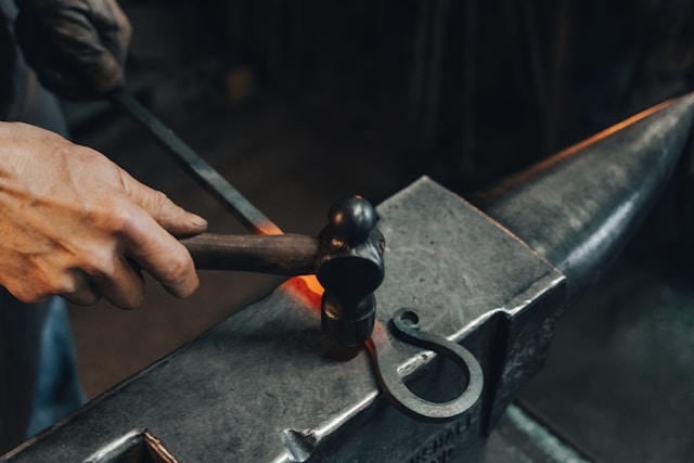 a hot metal rod being shaped into an ornament/tool